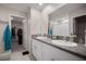 Bathroom featuring a granite countertop, dual sinks, and a doorway to the closet at 1823 Moon Cactus Ct, Ruskin, FL 33570