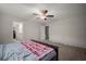 Neutral carpeted bedroom with ceiling fan and attached bathroom at 1823 Moon Cactus Ct, Ruskin, FL 33570