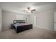 Neutral carpeted bedroom with ceiling fan and a black bedframe at 1823 Moon Cactus Ct, Ruskin, FL 33570