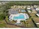 Community pool with lounge chairs and palm trees alongside a basketball court, cabana, and neighborhood homes at 1823 Moon Cactus Ct, Ruskin, FL 33570