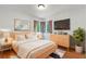 Cozy bedroom with a bed, dresser, mounted TV, and stylish decor at 18816 Carr Dr, Lutz, FL 33559