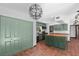 Open kitchen with stainless appliances, green cabinetry, and a wooden island with tile flooring at 18816 Carr Dr, Lutz, FL 33559