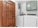 Laundry room with washer, dryer, hot water heater, carved wood door and cabinet at 18816 Carr Dr, Lutz, FL 33559