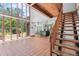 Open-concept living room with terracotta flooring, modern kitchen, and a wooden staircase at 18816 Carr Dr, Lutz, FL 33559