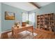 Bright home office with desk, chair, bookshelf, and light blue walls at 18816 Carr Dr, Lutz, FL 33559