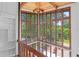 Upstairs sunroom featuring large windows with views of the trees, with a wooden banister at 18816 Carr Dr, Lutz, FL 33559