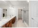 Bathroom featuring double sink vanity, generous mirrors, and a glass shower enclosure at 2131 River Turia Cir, Riverview, FL 33578