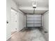 Empty garage with white walls, a sectional garage door, and a side entry door at 2131 River Turia Cir, Riverview, FL 33578