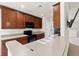 Well-lit kitchen with cherry wood cabinetry, laminate countertops, and modern appliances at 2131 River Turia Cir, Riverview, FL 33578