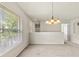 Bright and airy living room area featuring a chandelier and natural light from large windows at 2131 River Turia Cir, Riverview, FL 33578