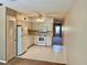 This kitchen features standard appliances, white cabinets, laminate countertops, and access to other rooms at 2287 Philippine Dr # 29, Clearwater, FL 33763