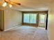 View of the carpeted living room featuring a window and door to a balcony, with neutral paint at 2287 Philippine Dr # 29, Clearwater, FL 33763