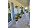 Inviting front porch with decorative plants, updated wall sconces and tiled flooring at 2310 Medford Ln, Brandon, FL 33511