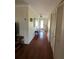 Long hallway with hardwood floors, closet space, and neutral paint offering a welcoming transition between rooms at 2310 Medford Ln, Brandon, FL 33511