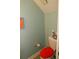 This is a basic half bath with a neutral colored wall, toilet and red seat at 2513 Newbern Ave, Clearwater, FL 33761