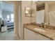 Bathroom vanity featuring granite counters, white cabinets, and a view to the primary bedroom at 2717 Via Cipriani # 631B, Clearwater, FL 33764