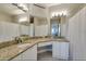 Bathroom with granite counters, double sinks, a large mirror, and shower with tub at 2717 Via Cipriani # 631B, Clearwater, FL 33764