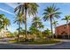 Lush community entrance featuring well-maintained landscaping, tall palms, and colorful flowers at 2717 Via Cipriani # 631B, Clearwater, FL 33764