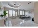 Bright living room features tray ceilings, tile floors, modern furnishings, and an abundance of natural light at 2717 Via Cipriani # 631B, Clearwater, FL 33764