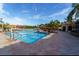 Pool with a volleyball net and an array of lounge chairs and tables with umbrellas at 2717 Via Cipriani # 631B, Clearwater, FL 33764