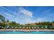 Pool with lounge chairs and umbrellas overlooking a treeline and a blue sky at 2717 Via Cipriani # 631B, Clearwater, FL 33764