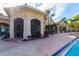 Pool with a building featuring stone accents, arched windows, and palm trees at 2717 Via Cipriani # 631B, Clearwater, FL 33764