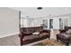 A spacious living area featuring a wood floor, leather couches, and a view of the front entry at 307 Orangewood Ln, Largo, FL 33770