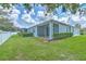 Spacious backyard featuring a screened-in lanai, lush green grass, and privacy fencing at 32829 Woodthrush Way, Wesley Chapel, FL 33545
