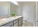 Bright bathroom features double sinks, a large mirror, and a glass-enclosed shower at 32829 Woodthrush Way, Wesley Chapel, FL 33545