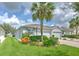 Charming single-story home features a lush, landscaped front yard with vibrant plants and a well-manicured lawn at 32829 Woodthrush Way, Wesley Chapel, FL 33545