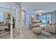 Bright, modern living room with neutral tones and large sliding doors to the outdoor space, complemented by an adjacent office at 32829 Woodthrush Way, Wesley Chapel, FL 33545