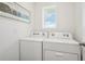 A well-lit laundry room featuring a side-by-side washer and dryer, and nautical wall art at 33096 Osprey Peak Way, San Antonio, FL 33576