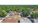 Aerial view of neighborhood with tree-lined streets and homes with blue tarped roofs at 4034 Paddlewheel Dr, Brandon, FL 33511