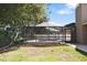 Spacious backyard with grass, a screened-in pool, and some trees at 4034 Paddlewheel Dr, Brandon, FL 33511