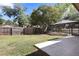 Spacious backyard with a screened-in pool, wooden fence, trees, and grass at 4034 Paddlewheel Dr, Brandon, FL 33511