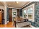 Charming dining room showcasing bold wallpaper, hardwood floors, and a barn door to the kitchen at 4334 18Th N St, St Petersburg, FL 33714