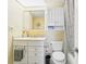 Well-lit bathroom featuring a vanity with storage, mirror, toilet, and shower with patterned curtain at 4725 Cove Cir # 604, St Petersburg, FL 33708