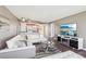 Open concept living room featuring a white sectional sofa, modern lighting, and a flat screen television with fireplace stand at 4725 Cove Cir # 604, St Petersburg, FL 33708
