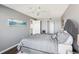 Bright main bedroom with a gray patterned comforter, ceiling fan, and ensuite bathroom at 4725 Cove Cir # 604, St Petersburg, FL 33708