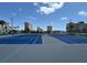 Well-maintained blue and gray tennis courts with surrounding buildings, providing an active lifestyle at 4725 Cove Cir # 604, St Petersburg, FL 33708