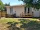 View of the home's backyard with small wooden deck and a partially fenced yard at 4801 Haines N Rd, St Petersburg, FL 33714