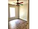 Bedroom with a colorful ceiling fan, natural light, and wood-look flooring at 4801 Haines N Rd, St Petersburg, FL 33714