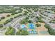 Aerial view of community with pool, tennis courts, a basketball court, and neatly arranged residential blocks at 5429 Legend Hills Ln, Spring Hill, FL 34609