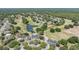 Aerial view of community featuring well-maintained golf course, lush landscaping, and serene pond at 5429 Legend Hills Ln, Spring Hill, FL 34609