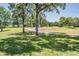 Lush backyard with mature trees and a well-maintained lawn on a sunny day at 5429 Legend Hills Ln, Spring Hill, FL 34609