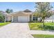 Home boasts a brick driveway and beautiful lawn at 5429 Legend Hills Ln, Spring Hill, FL 34609