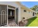 Elegant front entrance with a secure screen door and beautifully landscaped surroundings at 5429 Legend Hills Ln, Spring Hill, FL 34609