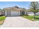 Charming single-story home featuring a brick driveway and meticulously maintained landscaping at 5429 Legend Hills Ln, Spring Hill, FL 34609