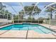 Inviting screened-in pool area featuring a waterfall and serene views of the surrounding landscape at 5429 Legend Hills Ln, Spring Hill, FL 34609