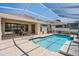 Backyard features a sparkling swimming pool, covered patio and lush landscaping at 5429 Legend Hills Ln, Spring Hill, FL 34609